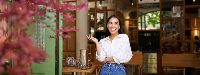 Portrait of young woman standing in city