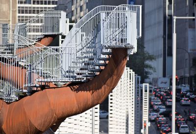 Close-up of hand against buildings in city