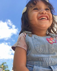 Portrait of smiling girl against sky