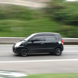 Side view of car moving on road