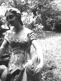 Portrait of young woman with horse statue in park