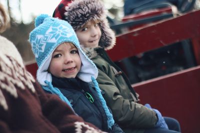 Two white boys with winter hats in a wagon