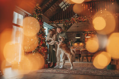 Candid authentic happy family during wintertime together enjoying holidays with dog at xmas