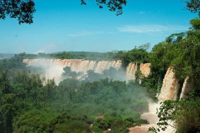 Scenic view of waterfall against sky