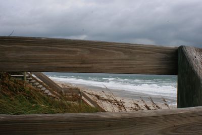 Wooden structure against cloudy sky