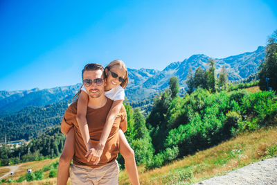 Couple standing on mountain against sky