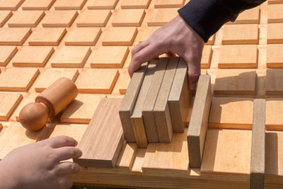 Cropped image of people holding wood