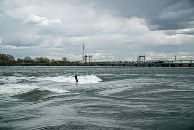 Man surfing in sea against sky