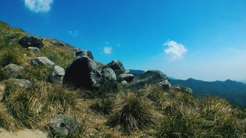 Panoramic view of sea by rocks against blue sky