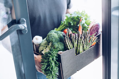 Man holding vegetables in container