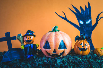 View of various pumpkins against orange wall