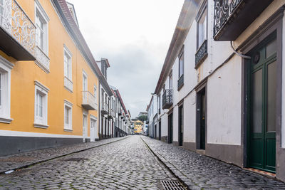 Empty alley amidst buildings in city