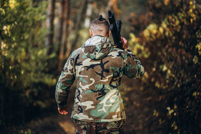 Rear view of man standing against trees