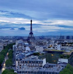 Buildings in city against cloudy sky