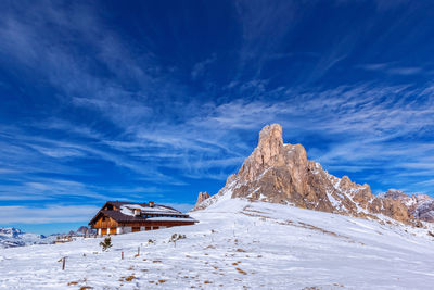 Built structure on snowcapped mountain against blue sky