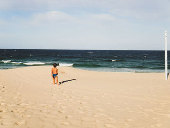 People on beach against sky
