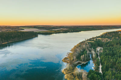 Scenic view of river against clear sky during sunset