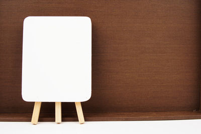 Directly above shot of empty chair on table against white wall