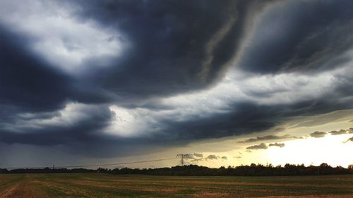 Scenic view of field against dramatic sky