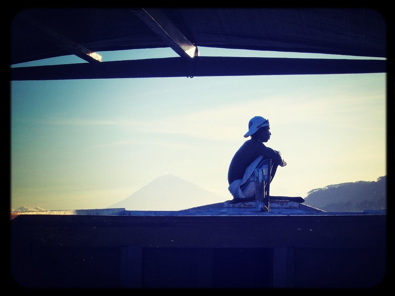 transfer print, sky, auto post production filter, architecture, built structure, building exterior, mountain, sunlight, men, house, full length, silhouette, lifestyles, rear view, cloud - sky, cloud, standing, day