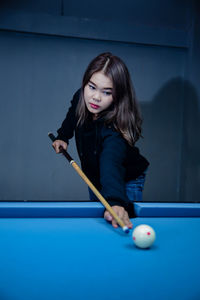 Young woman playing pool