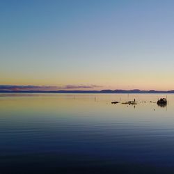 Scenic view of sea against clear sky at sunset