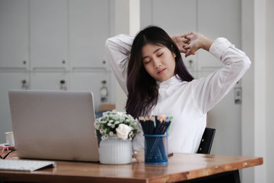 Young woman using phone on table