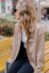 Blond girl sitting in a bench