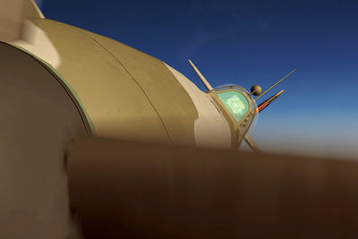 Low angle view of airplane against clear blue sky