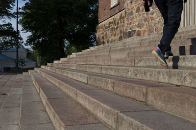 Low section of man walking on staircase