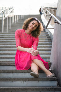 Portrait of young woman sitting on wall