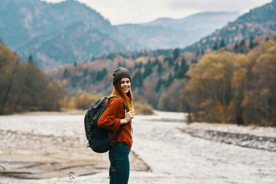 Portrait of young woman standing on mountain during winter