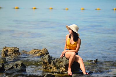 Full length of young woman on rock at beach