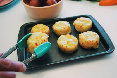 Close-up of hand holding food on table