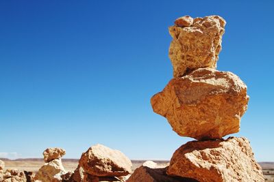 Close-up of rocks against clear blue sky
