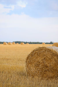 Hay bales on field against sky