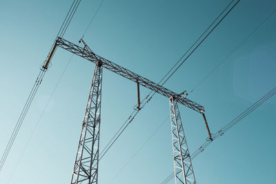 Low angle view of electricity pylon against clear sky