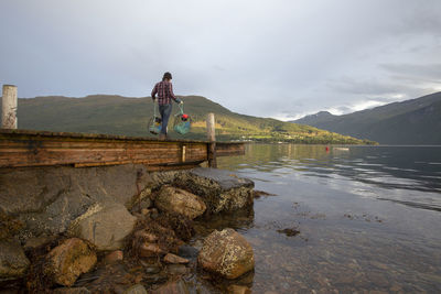 A fisherman walks along a dock in norway