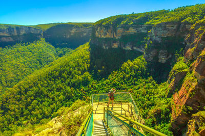 High angle view of woman standing by railing against landscape