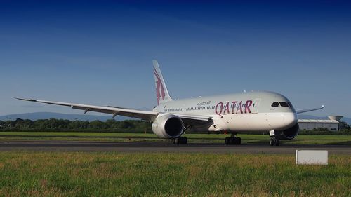 Airplane on runway against clear blue sky