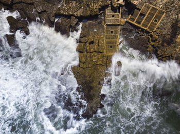 Aerial view of sea waves splashing on rocks