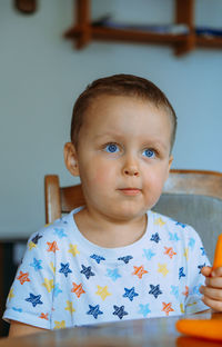 Portrait of cute boy eating food at home