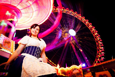 Low angle view of young woman in amusement park
