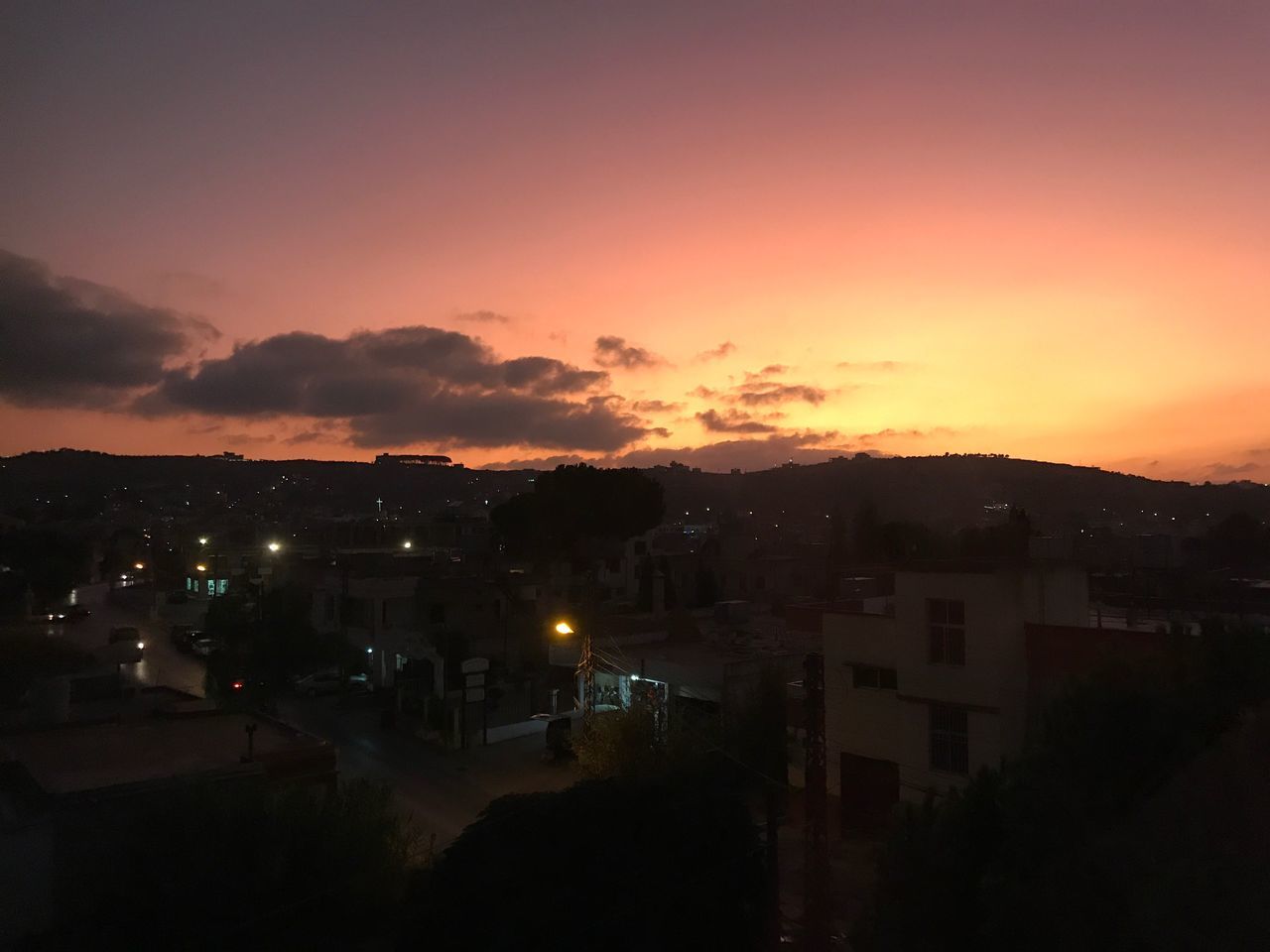 ILLUMINATED CITYSCAPE AGAINST SKY DURING SUNSET