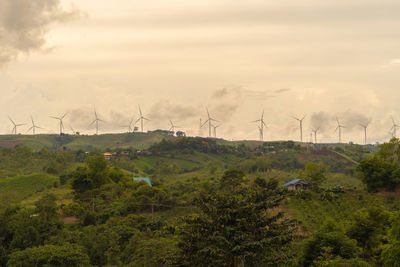 Windmill on field against sky during sunset