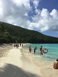 People at beach against sky