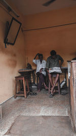 Men sitting on table against wall