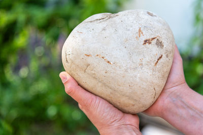 Close-up of hand holding heart shaped rock