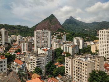 View of cityscape against cloudy sky