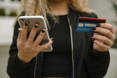 Young woman shopping with smart phone and credit card